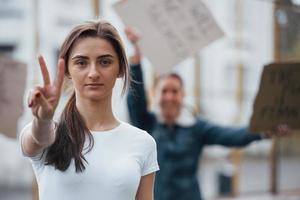 Geste mit zwei Fingern. Eine Gruppe feministischer Frauen protestiert im Freien für ihre Rechte foto