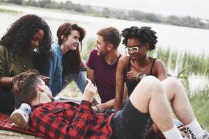 auf roter Decke. gruppe von menschen picknickt am strand. Freunde haben Spaß am Wochenende foto