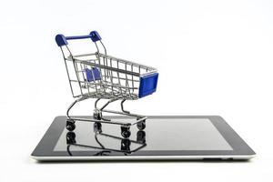Einkaufswagen mit Tablet auf weißem Hintergrund, bedeutet Online-Shopping