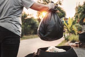 frauenhand, die müllbeutel für die recyclingreinigung hält foto