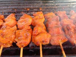 Auf dem Grill gebratene Hähnchenstücke aufspießen und räuchern. gegrilltes Hühnchen foto