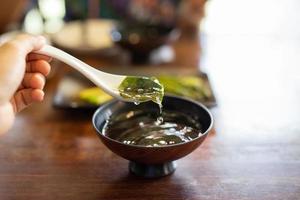 Hand mit Löffel, die traditionelle japanische Algensuppe isst. foto