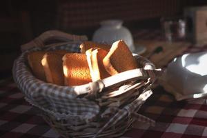 Zwieback im Korb auf einem Frühstückstisch am frühen Morgen foto