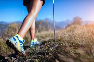 Nordic Walking auf Schotterweg. eine junge Frau im Berg foto