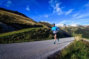 Laufen auf einer ansteigenden Straße in den hohen Bergen foto