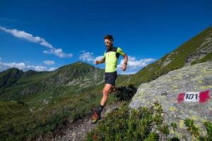 männlicher athlet, der berglauf auf einem weg bergab übt foto