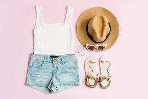 mode sommer damenkleidung set mit accessoires auf rosa hintergrund, flache lage, draufsicht foto