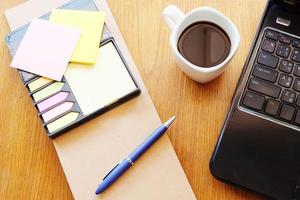 Notizbuch und Laptop auf Holztisch mit Kaffee foto