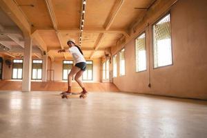 skater-frau, die skateboard in der sporthalle spielt, junge asiatische frau ist glücklich und macht spaß mit dem skateboarding-lebensstil in der stadt, jugendliche hipster-weibliche trendige mode foto