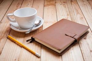 Kaffeetasse mit Notizbuch und Bleistift