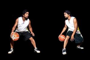 Geste des asiatischen Basketballspielers, der auf schwarzem Hintergrund dribbelt. Basketballkonzept in Asien foto