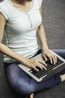 junge Frau sitzt beim Verwenden des Laptops