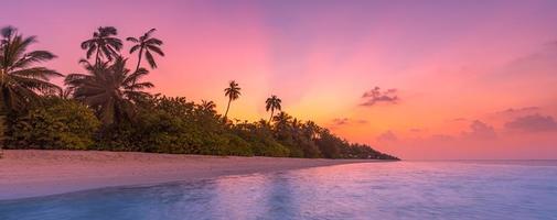 Palmen am tropischen Strand, atemberaubender Sonnenuntergang, tropische Inselküste. sonnenstrahlen, träumen romantische exotische strandlandschaft. Palmen, ruhiger Lagunenseehorizont. foto