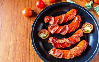 Bratwürste in einer Pfanne mit Tomaten und Brokkoli foto