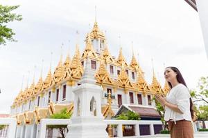 Eine junge Frau betet im Wat Ratchanatdaram, einer berühmten Touristenattraktion und Sehenswürdigkeiten in Bangkok, Thailand foto