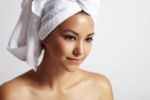 Schönheitsfrau mit einem weißen Handtuch auf dem Kopf foto