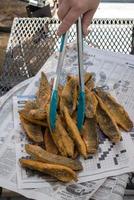 panierte Meerbarbenfilets auf Fischbrötchen auf Zeitungspapier ausgelegt foto