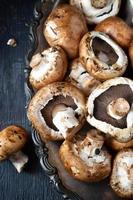 frische Champignons auf antikem Tablett und altem Holztisch foto