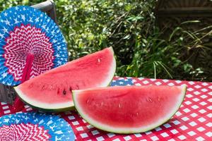 Geschnittene Wassermelone am 4. Juli Picknicktisch im Freien foto