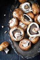 frische Champignons auf antikem Tablett und altem Holztisch foto