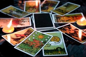 tarotlesung mit tarotkartenhintergrund und kerzenlicht auf dem tisch für astrologie okkulte magische spirituelle horoskope und handlese-wahrsager-tarotleser foto