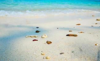schöner strand und blaues meer am strand mit felsen auf sandinsel natürlicher ozean foto