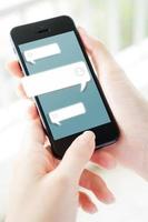 Hand einer Frau, die Text auf einem mobilen Smartphone eingibt. Online-Live-Chat-Chat auf Antrag foto