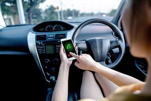 Nahaufnahme einer Frau, die beim Autofahren mit dem Handy telefoniert. foto