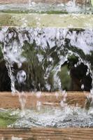 Spritzwassertropfen und Blasenkaskaden als Hintergrund das Konzept der Wasserfrische und Luftblasen auf der Wasseroberfläche. foto