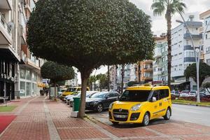 Seitentürkei 23. Februar 2022 gelbes Taxi Fiat Doblo wird an einem warmen Sommertag vor dem Hintergrund einer Straße, Bäume, auf der Straße geparkt foto