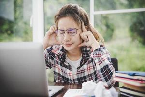 junge frustrierte frau, die im büro arbeitet foto