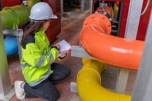 asiatischer ingenieur mit brille, der im heizraum arbeitet, wartungsüberprüfung der technischen daten der heizungssystemausrüstung, thailänder foto