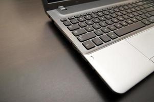 silberner Laptop mit schwarzer Tastaturnahaufnahme auf einem Schreibtisch foto