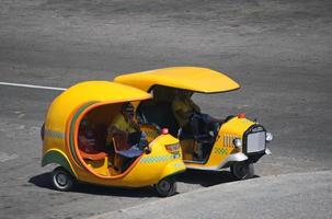 havanna, kuba - 2. juli 2019 - fahrer entspannen sich in ihrem coco-taxi, einem beliebten transportmittel in kuba. foto
