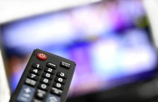 Fernbedienung und Bildschirm - Binge Watching der Lieblings-TV-Show foto