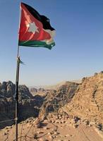 Nationalflagge von Jordanien in der zerklüfteten Landschaft von Petra, Jordanien foto