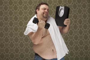 Übergewichtige männliche Haltewaagen arbeiten hart, um Gewicht zu verlieren foto