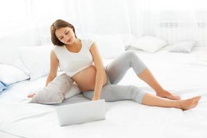 schwangere Frau mit Laptop-Computer foto