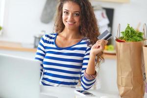 lächelnde Frau Online-Shopping mit Computer und Kreditkarte in foto
