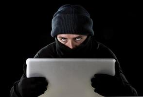 Hacker Mann in Schwarz mit Computer Laptop Cyber Crime Konzept