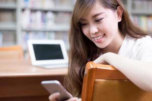 asiatische schöne Studentin mit Laptop und Handy