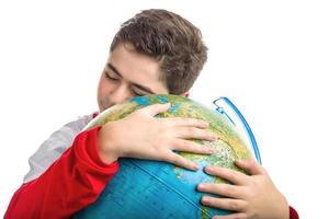kaukasischer Junge umarmt Globus foto