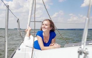 Reisekonzepte: lächelnde positive kaukasische Frau auf weißer Yacht foto