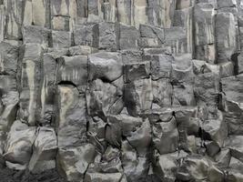 erstaunliche basaltgesteinsstrukturen am endlosen schwarzen strand von island. foto