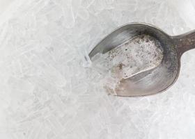 Eisschaufel aus Metall auf dem kleinen Eiswürfel. foto