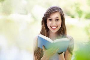 junge Frau, die Buch draußen liest