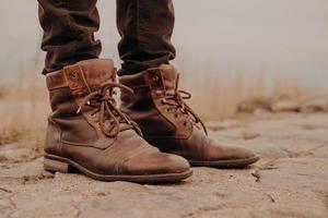 Bild der Beine des Mannes in alten Stiefeln. konzept des verkaufs von schuhen. Herbstzeit. horizontale Ansicht. Außenaufnahme. Schuhwerk foto