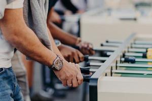 Tischkicker Kicker. Beste Freunde genießen die Zweisamkeit, erholen sich am Unterhaltungsort, spielen zusammen Tischfußball, haben Freizeit. menschen und ruhekonzept foto