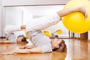 Frauen machen Fitnessübungen mit Ball