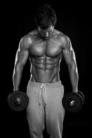 muskulöser Bodybuilder-Typ, der Übungen mit Hanteln macht foto